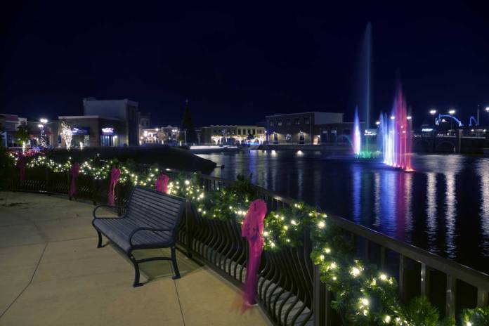 Night photograph of the pond with lighted fountain at the OWA village in Foley, Alabama, USA.