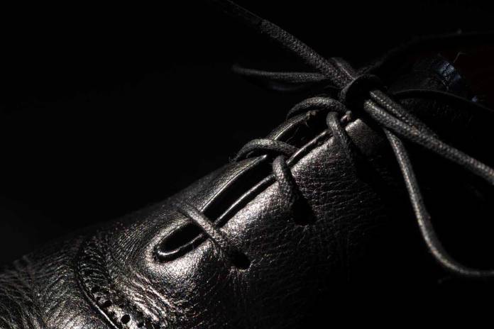 Close up photo of a classic man's shoe with bow-tied lace.